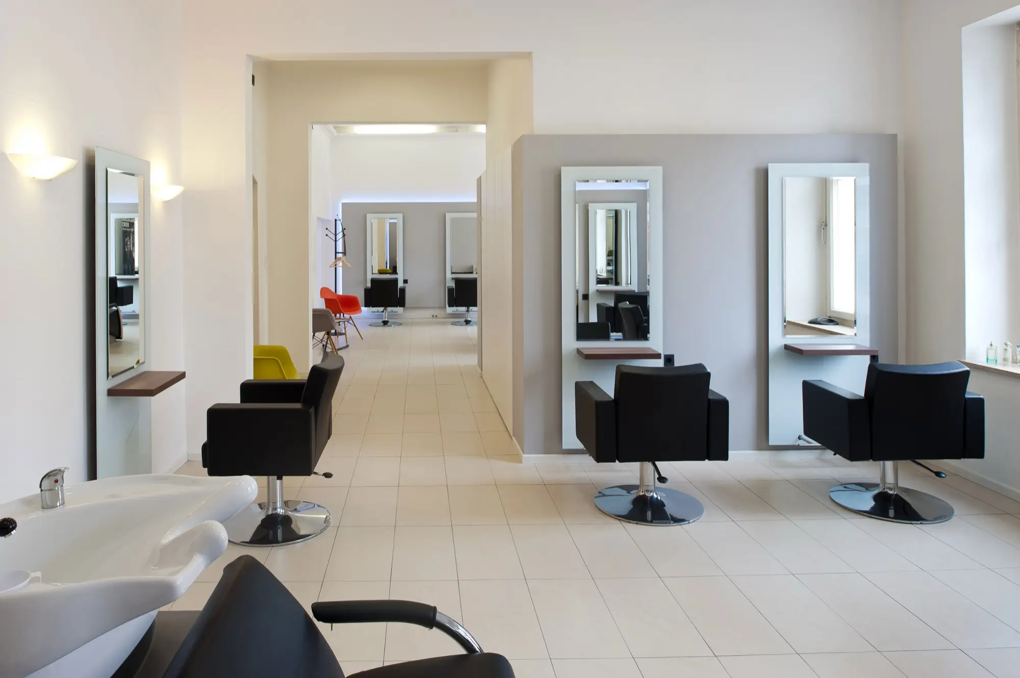 Blick durch den hellen Salon mit Bedienplätzen und Spiegeln